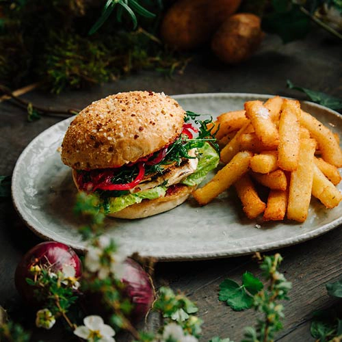 Ein hausgemachtes Knusperbrötchen mit Thüringer Bratwurst, Sauerkraut, Senf und Röstzwiebeln ist ein herzhaftes Vergnügen! Dazu Kloßpommes, Dips – eine perfekte Kombination für alle, die deftige Küche lieben!