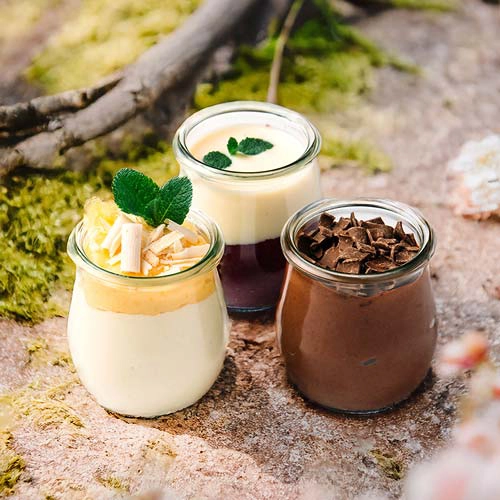 Die Schleckermäulchen sind drei Dessertvariationen: schokoladig, beerig und zitronig. Serviert jeweils in einem Glas. Drumherum sind Walddekorationen.