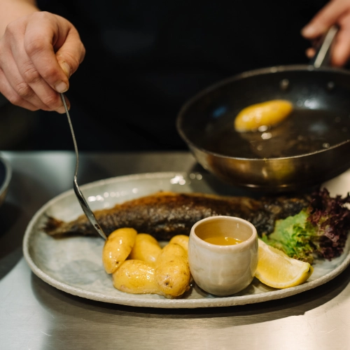 Eine Köchen richtet gerade ein Fischgericht an.