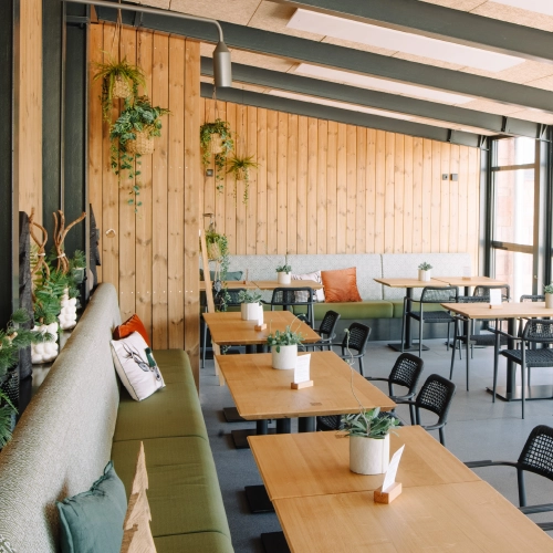 Die Loungeecke des Restaurants „O'Gretel“. Große Fenster durchfluten den Sitzbereich.